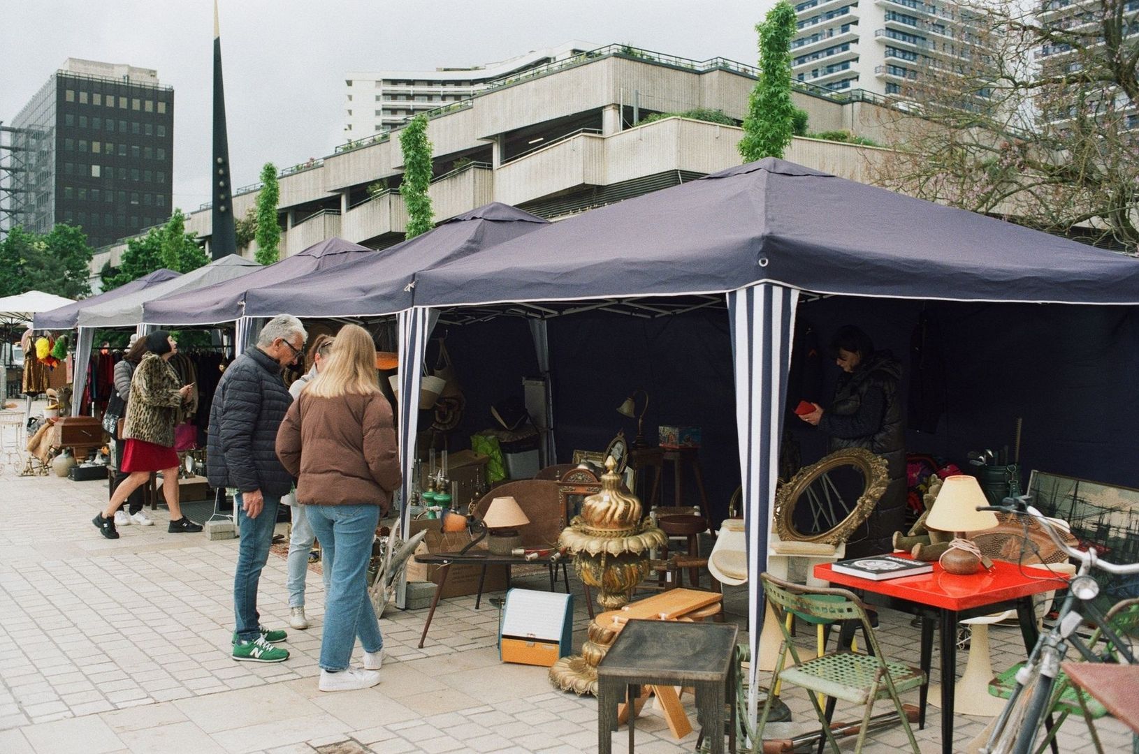 Gatumarknad med loppisbord och tält framför stadens höghus