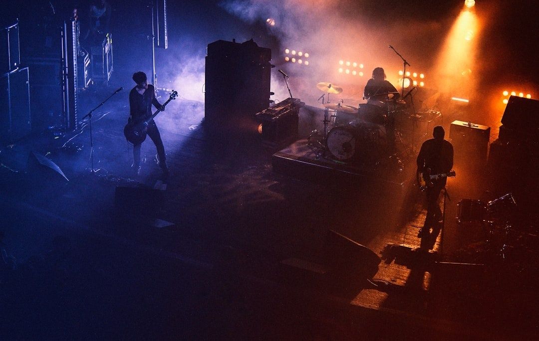 Liveband spelar i en rökfylld, mörk konsertlokal med färgat ljus