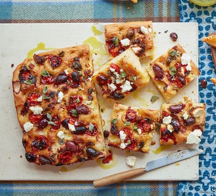 Focaccia med tomater, oliver och fetaost på en skärbräda